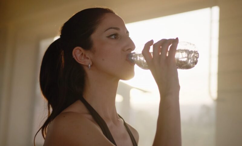 Woman drinking water after training