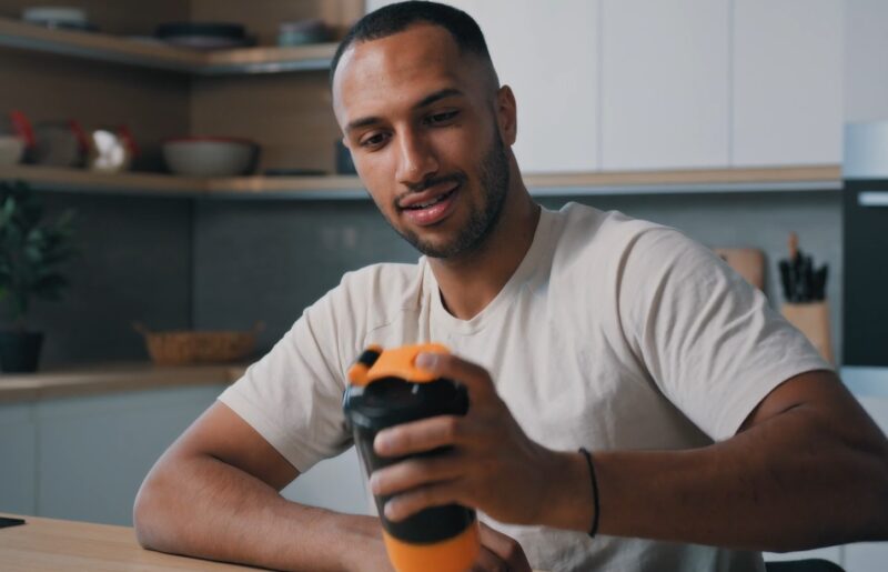 Runner drinks protein shake at home day after the race