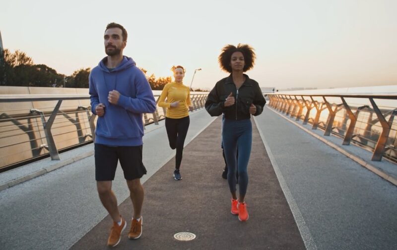 Three people jogging on a paved track