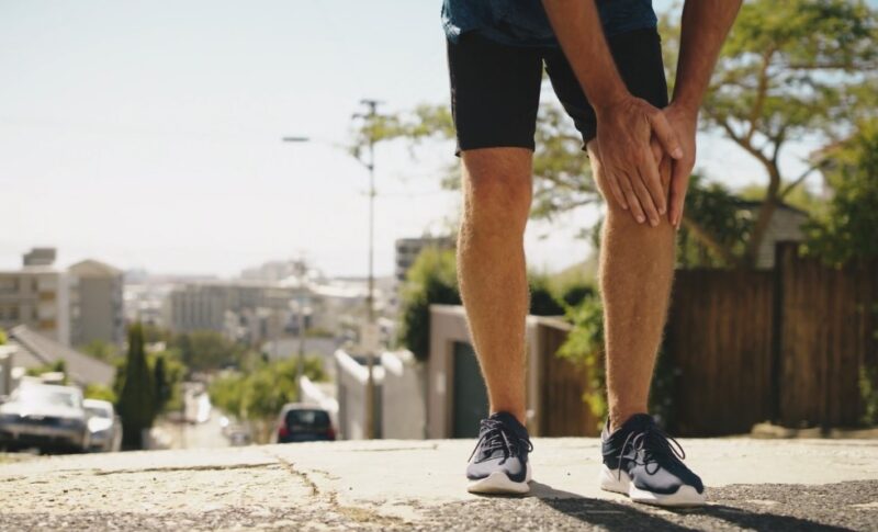 Runner holding his knee in pain