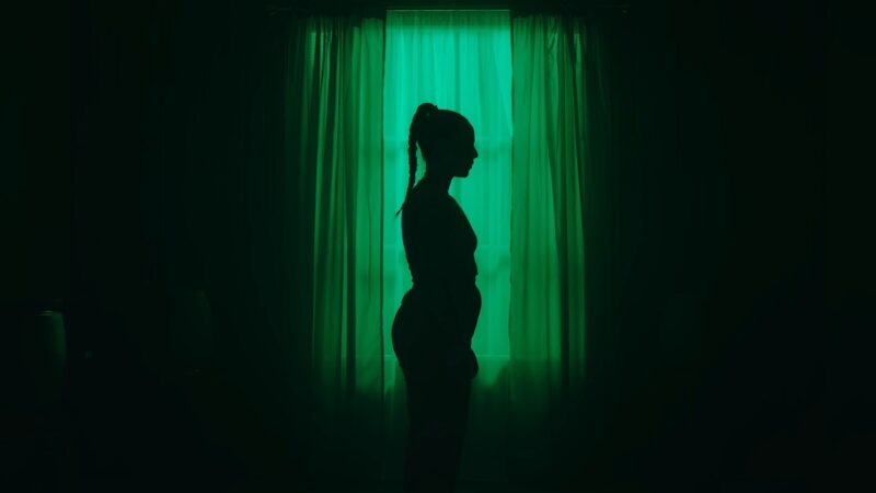 Silhouette of a girl in front of a mirror