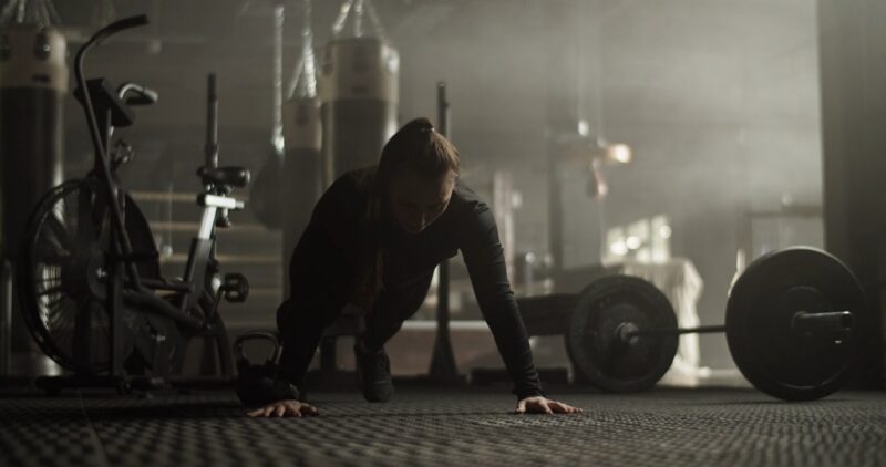 A girl is doing push-ups in the gym