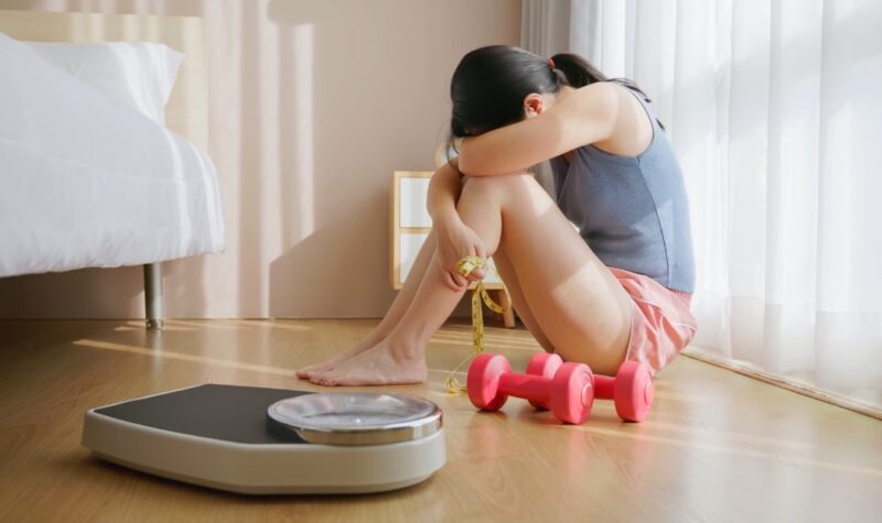 A young woman sits on the floor in despair