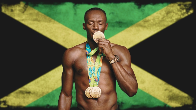 Usain Bolt Holding His Olympic Gold Medals with Pride Against the Jamaican Flag Background