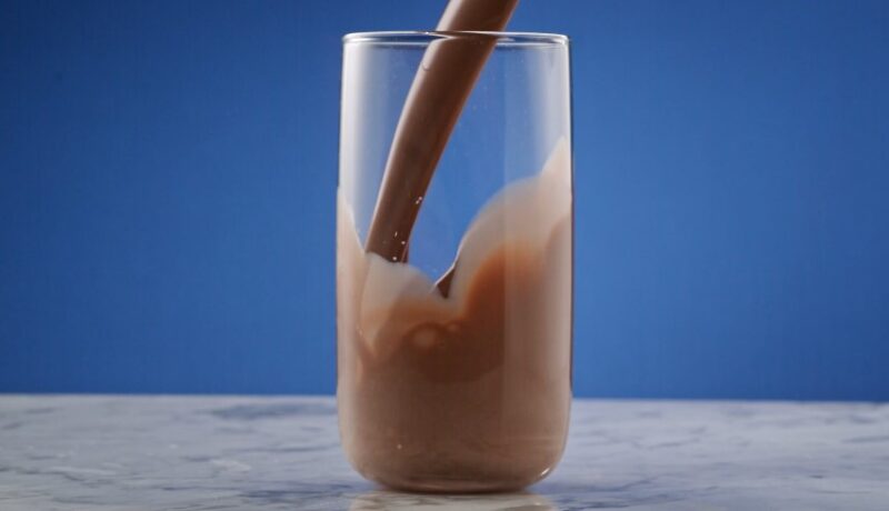 Chocolate milk is poured into a glass