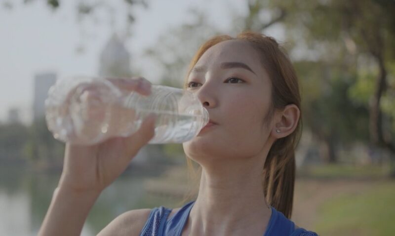 Woman drinks water after a run