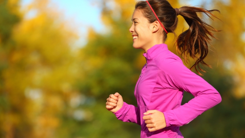 A Woman Enjoying Fall Running Outdoors in A Park