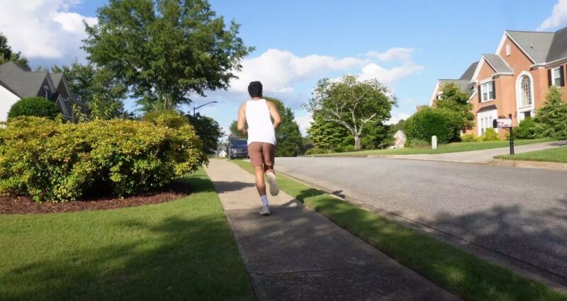 A man jogs down a residential street