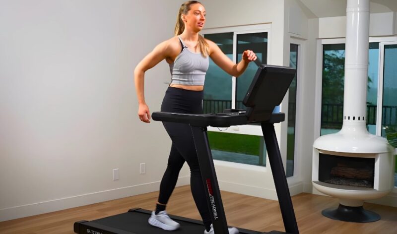 Woman strides confidently on a treadmill, enjoying a workout