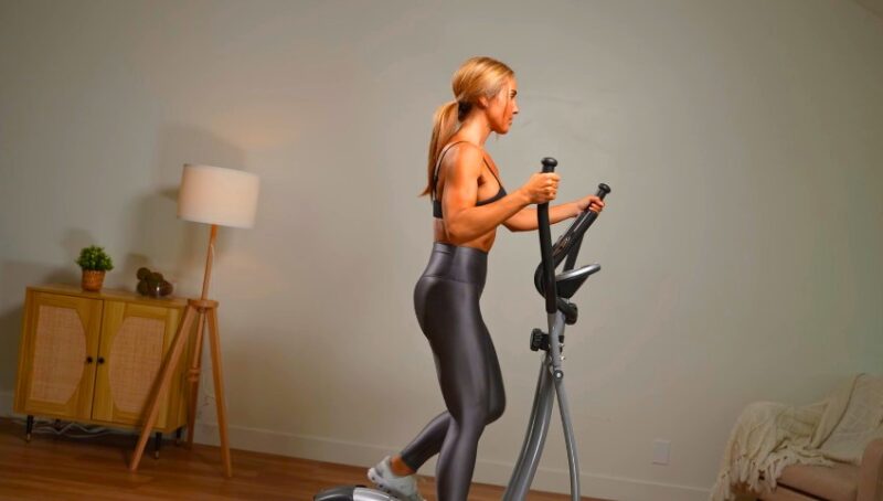 Woman using a cross-trainer, focused on her workout