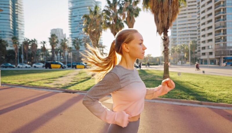 A woman enjoys a brisk run through a vibrant urban park