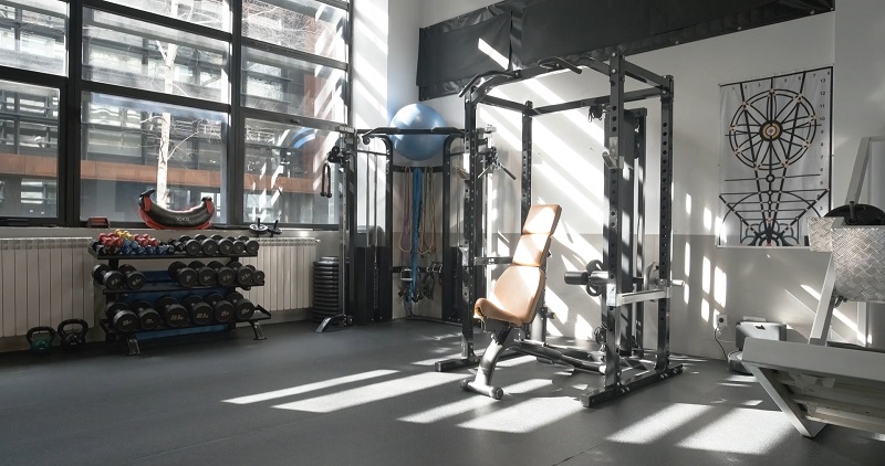 A gym with weight benches and dumbbells