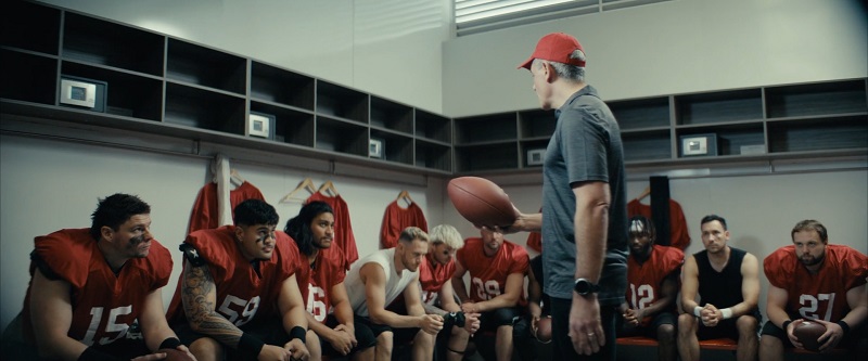 A football coach addressing his team in the locker room before a big game