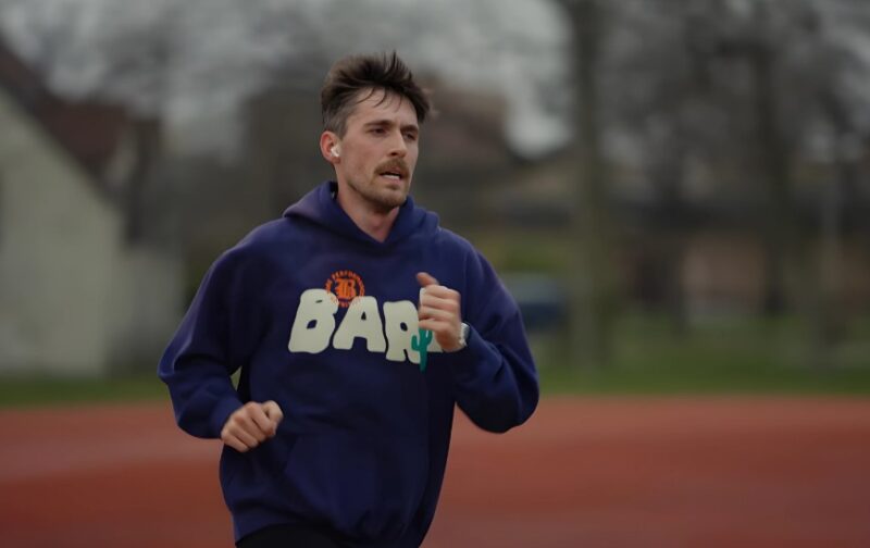 A man running in a purple hoodie on a bad weather day