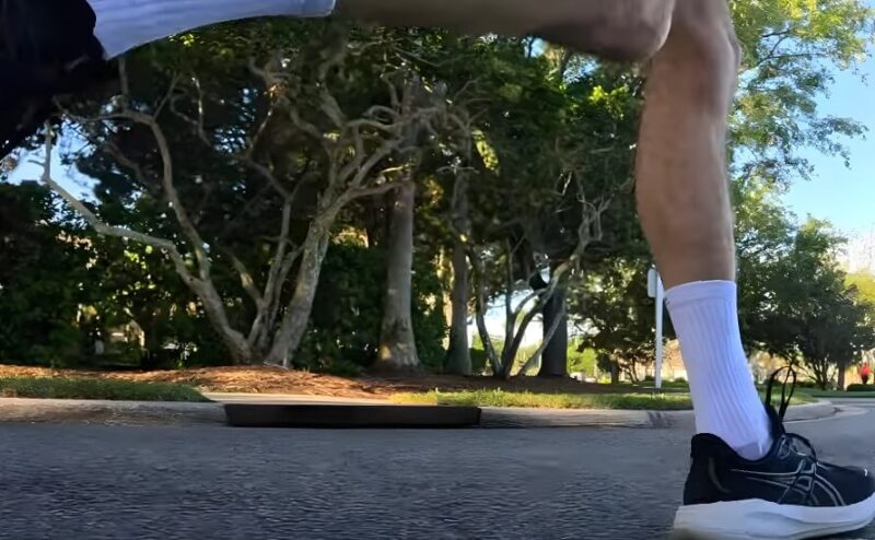 Close-up view of a runner's feet, showcasing the soles of athletic shoes on a paved surface