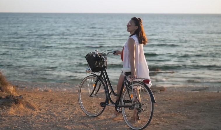 Woman on a bicycle, enjoying the coastal scenery