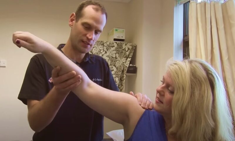 Physical therapist assessing a patient's shoulder range of motion