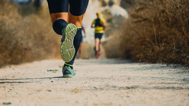 Close-up of trail runners on a dry mountain path, showing training methods for high-altitude running