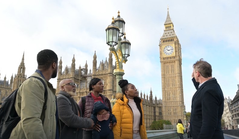 A group of diverse people stands together in front of Big Ben