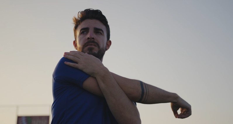 Male runner warms up his shoulder