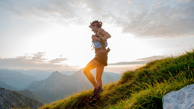 Woman running uphill at sunrise, showing increased red blood cell production in high altitude running