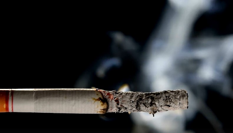A spent cigarette, its filter stained with the residue of burnt desires