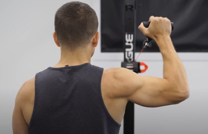 Man performing a shoulder exercise using a cable machine