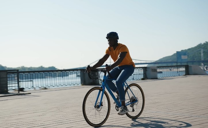 A man cruises along a waterfront path, enjoying the sunny day