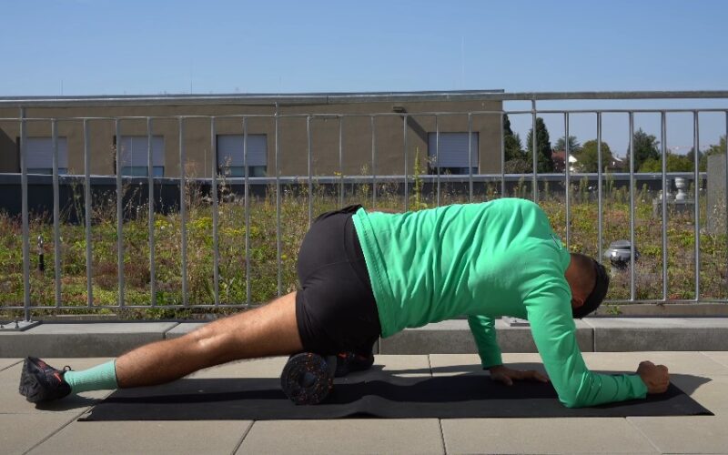 Male runner doing stretches on a foam roll