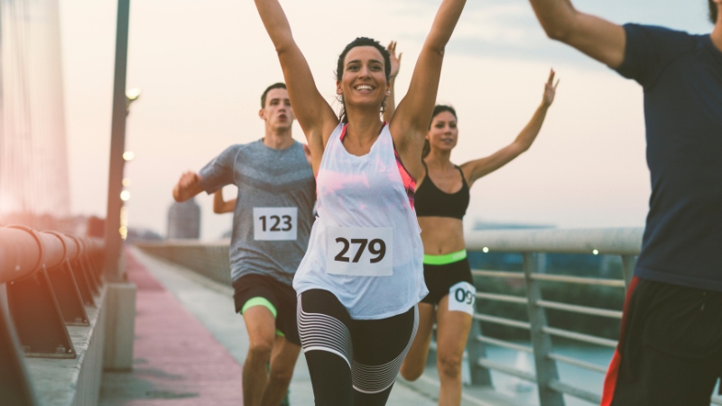 Runners crossing the finish line of a marathon, showing relief and joy after completing the race