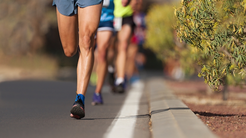 Runners moving along a road during a marathon, focused and concentrated in the middle of the race