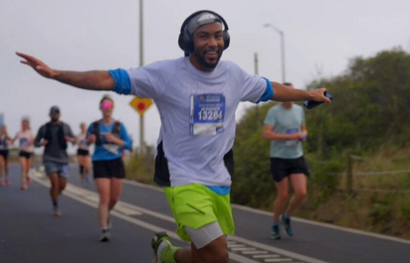Runner in motion, arms outstretched, enjoying the marathon