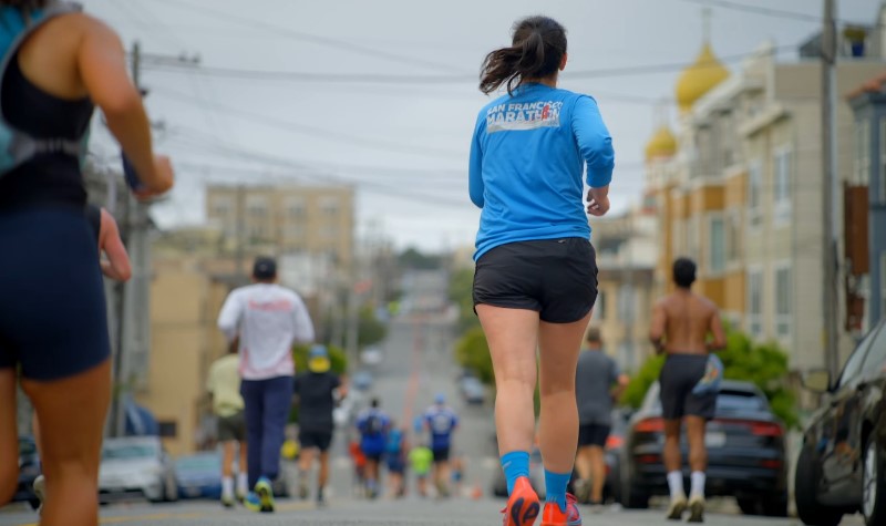 Runners navigate a city street, focused on the finish line