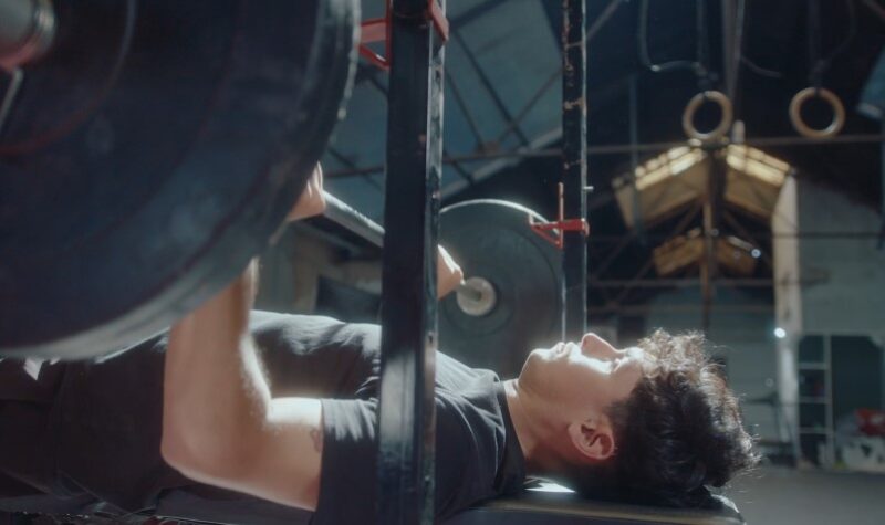 A man performs a bench press, showing dedication and strength