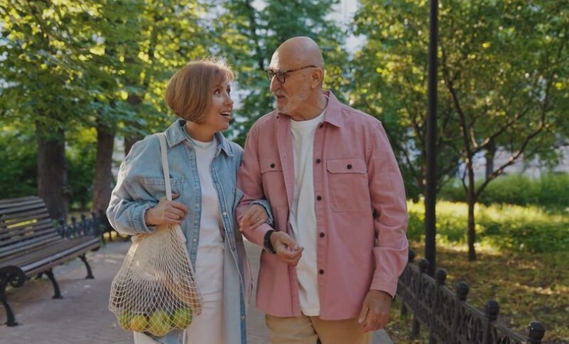 Elder couple walking through a park