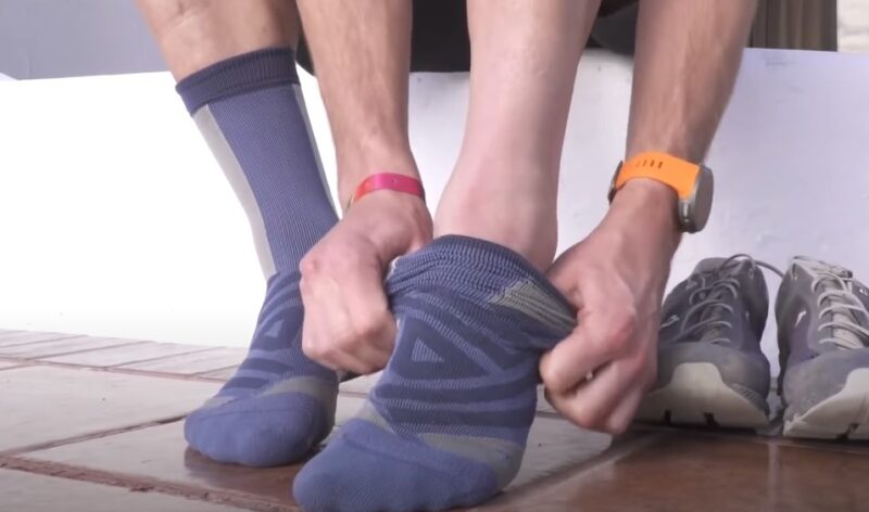 A person carefully puts on athletic compression socks