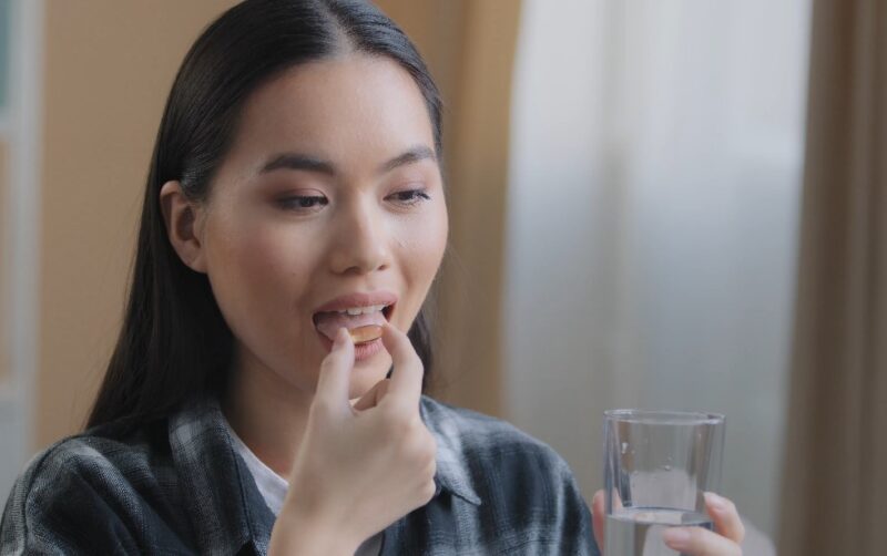 Woman puts magnesium pill in her mouth