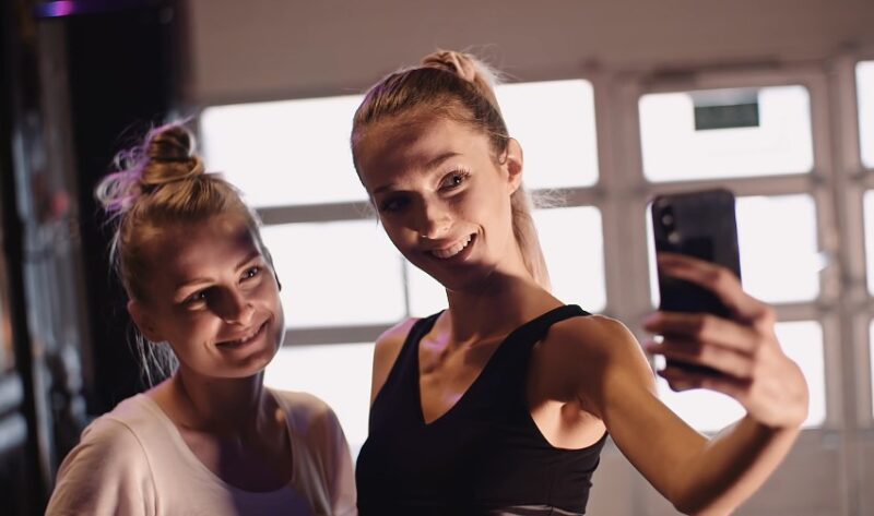 Two women capture a moment of camaraderie in a fitness studio