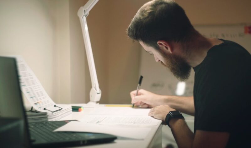 Man studying, writting down important notes
