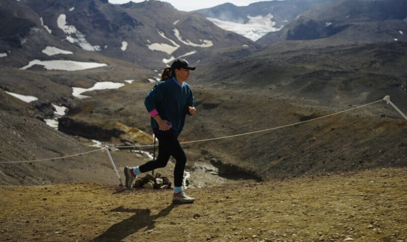 A female runner navigates a rugged mountain path