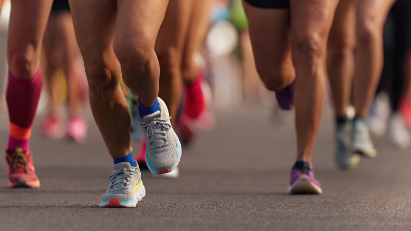 Runners’ legs moving fast during their first half marathon race