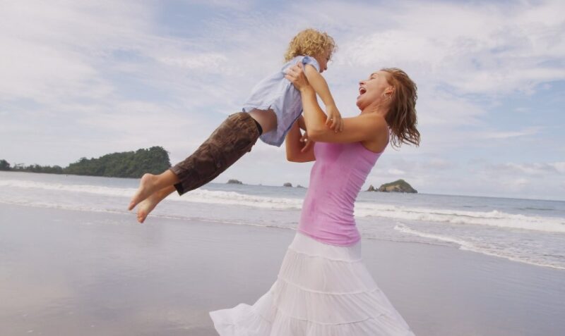 Mom playing with her kid on a beach