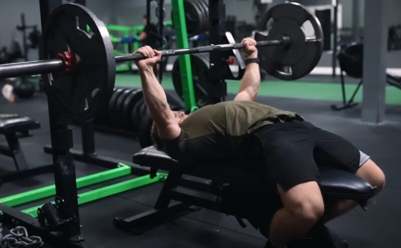 A focused lifter pushes a heavy barbell, showcasing strength and dedication