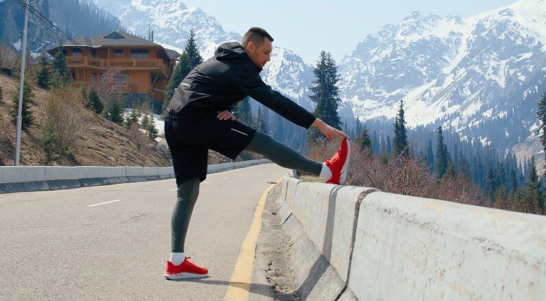 Male runner stretching after running session