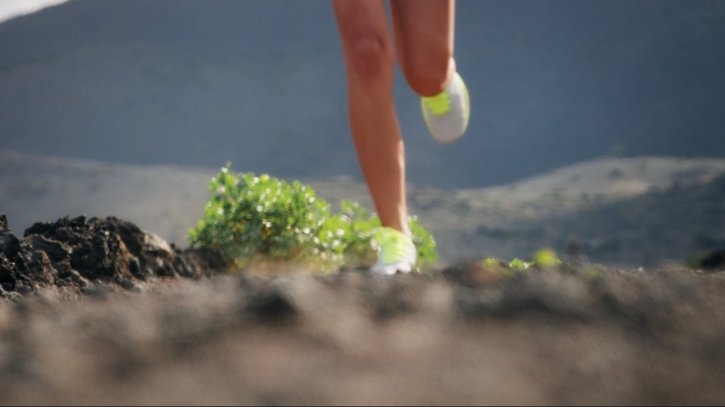 A runner’s legs move fast over rocky ground in bright shoes, captured in one of the top running documentaries