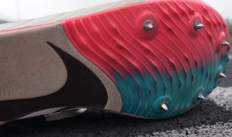 Close up of a white-red-blue track running shoe