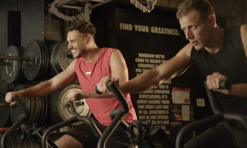 Two men engaged in intense exercise on stationary bikes