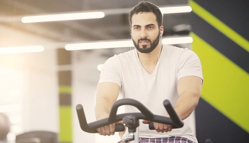 Man cycling on a stationary bike, enjoying his workout
