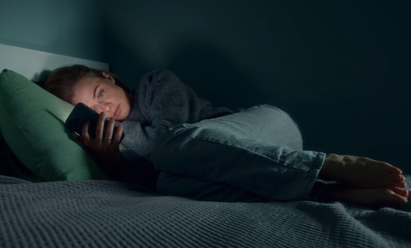 Woman looking at her phone before the sleep
