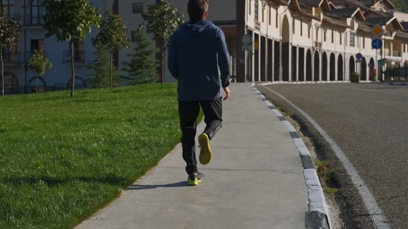 Man jogging on a sidewalk in intervals for cardio endurance